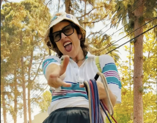 Rachel holding a handful of rope leads with the pack around her